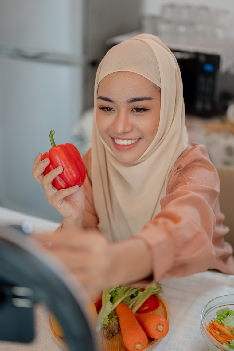 An attractive Asian Muslim female influencer or food blogger is